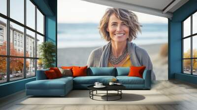 Portrait of smiling mature woman standing on beach at the day time Wall mural