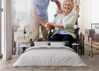 Surrounded by support. Shot of a smiling caregiver with a senior woman in a wheelchair and her husband at home. Wall mural