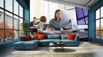 Technology ensures their workday is a productive one. Shot of colleagues working on their computers in an open plan office. Wall mural