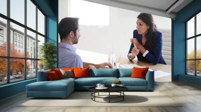 What distinguishes you from all the other candidates. Shot of a businesswoman interviewing a job applicant in an office. Wall mural