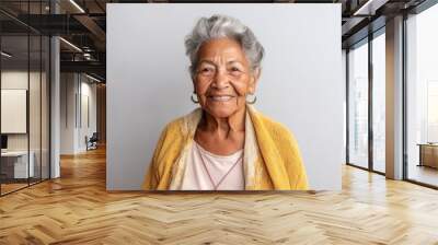 Medium shot portrait photography of a 100-year-old elderly Colombian woman against a minimalist or empty room background Wall mural