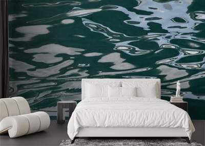 Sunlight is reflected off dark green water. The light is distorted by the movement of the water, creating an abstract image. Wall mural