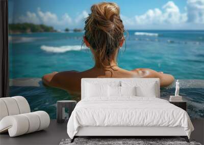 back view young adult female person enjoy relax in infinity edge luxury outdoor swimming pool looking on ocean view in warm sunset light. Tropical wellness travel vacation tourism concept Wall mural