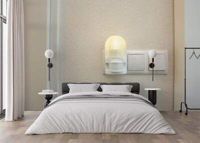 Night light plug in white socket on white wall turns on automatically in modern house Wall mural