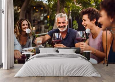 group of friends having dinner in the garden enjoying their life. Tavolata setting, red wine  Wall mural