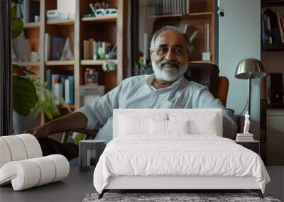 Portrait of a mature experienced senior indian business man taking a break in her chair in his home office Wall mural