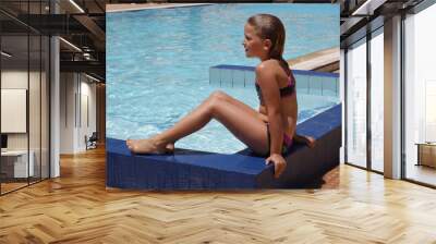 Young girl sitting by the pool Wall mural