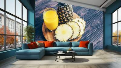 Pineapple fruit and juice on a board on a wooden table Wall mural