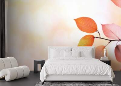 A beautiful autumn scene with leaves on a tree. The leaves are orange and yellow, and they are falling from the tree. The sky is blue, and there are some clouds in the sky Wall mural