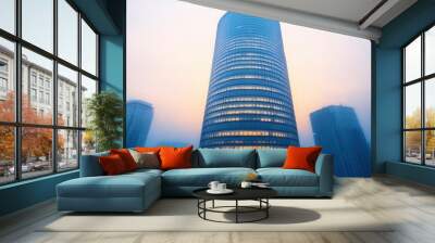 Blue skyscraper from below with bright sunny sky background Wall mural