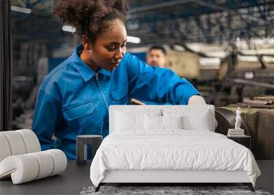 African American Young woman worker  in protective uniform operating machine at factory Industrial.People working in industry.Portrait of Female  Engineer at work place. Wall mural