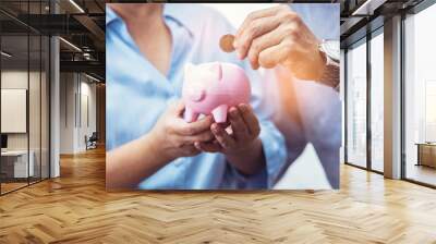 Asain Elder  putting coin money to piggy bank saving, family, savings, age and people concept - smiling senior couple with money and piggy bank at home. Wall mural