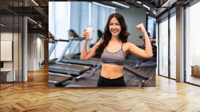 Attractive fitness asian woman finishing workout and drinking protein milk shake vitamins after training. Bodybuilding. Healthy lifestyle. Wall mural