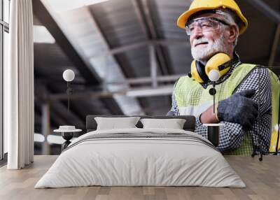 Industrial Engineers in Hard Hats.Work at the Heavy Industry Manufacturing Factory.industrial worker indoors in factory.aged man working in an industrial factory. Wall mural