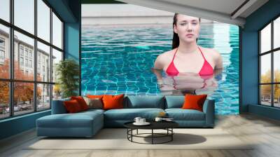 Portrait of beautiful  woman in red swimwear relaxing in swimming pool spa. Hot summer day and bright sunny light. Wall mural