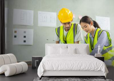 Professional of team Asian engineers and  foreman in helmets working meeting with blueprint and construction tools on table at the construction site. Wall mural