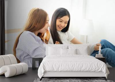 Young asian happy woman planning for travel in bed room .Check-in online for booking her flight trip. Wall mural