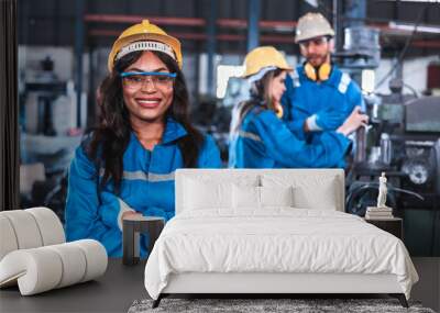 Young people worker in protective uniform operating machine at factory Industrial.People working in industry.Portrait of Female Engineer looking camera at work place. Wall mural