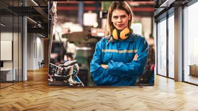 Young people worker in protective uniform operating machine at factory Industrial.People working in industry.Portrait of Female Engineer looking camera at work place. Wall mural