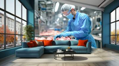 A dedicated worker in blue gear skillfully prepares chicken meat on a busy processing line, showcasing the raw intricacies of food production Wall mural