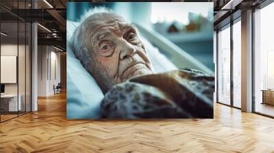 An elderly man lies peacefully in a hospital bed, surrounded by medical equipment, lost in thought Wall mural