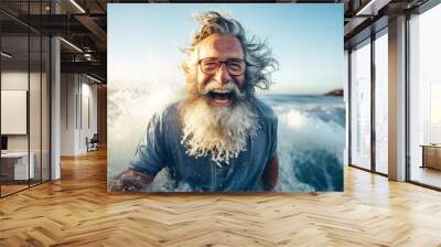 An elderly man with a beard swims in the sea waves. Close-up portrait. Happy emotions. Active lifestyle. Relaxation on the beach. Wall mural