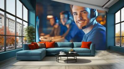 Close-up of a smiling call center worker in a headset focused on his computer at work while colleagues are engaged in the background under cinematic lighting Wall mural