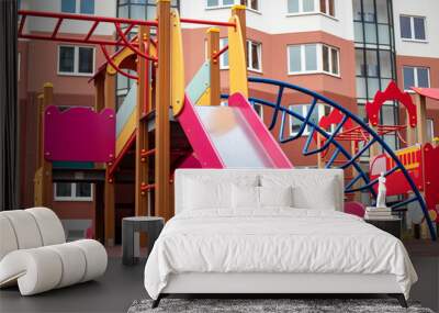 Colorful playground equipment in a modern residential area invites children to play and explore during a sunny day Wall mural