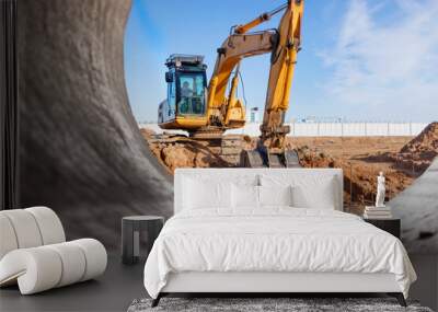 Heavy excavator at the construction site. View of the excavator through the iron pipe. Construction equipment for earthworks. Quarry excavator. Wall mural