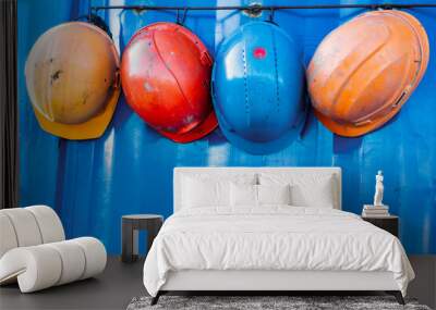 Multi-colored protective construction helmets. Coordinated work of the construction team. Safety in construction. Contractor on site. Wall mural