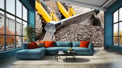 Powerful wheel loader or bulldozer against the sky. Loader transports crushed stone or gravel in a bucket. Powerful modern equipment for earthworks and bulk handling. Wall mural