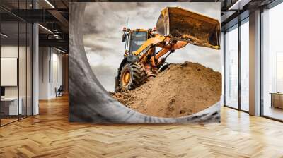 Powerful wheel loader or bulldozer working on a quarry or construction site. Loader with a full bucket of sand against the sky. Powerful modern equipment for earthworks. Wall mural