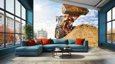 Powerful wheel loader or bulldozer working on a quarry or construction site. Loader with a full bucket of sand. Powerful modern equipment for earthworks. Wall mural