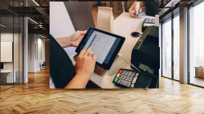 Closeup shot of caucasian cashier hands. Seller using touch pad for accepting client customer payment. Small business of coffee shop cafeteria. Wall mural