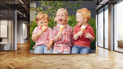 Group portrait of three white Caucasian cute adorable funny children toddlers sitting together sharing ice-cream food. Love friendship fun concept. Best friends forever. Wall mural