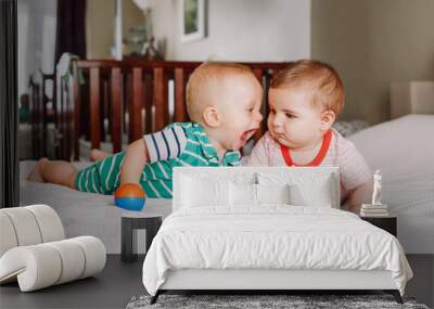 Group portrait of two white Caucasian cute adorable funny baby boys lying together on bed communicating and playing. Friendship childhood concept. Best friends forever. Children fighting Wall mural