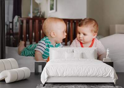 Group portrait of two white Caucasian cute adorable funny baby boys lying together on bed communicating and playing. Friendship childhood concept. Best friends forever. Children talking Wall mural