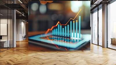 A digital tablet displaying a rising bar graph, symbolizing growth and success in business and finance concepts. Wall mural