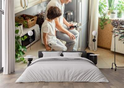 Man and Kid Operating Robotic Vacuum Cleaner Wall mural