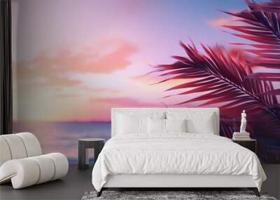 Close up of palm leaves with sunset sea in soft tones. Beautiful nature background. Wall mural