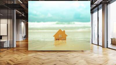 Closed up tiny home models on sand with sunlight and beach. Wall mural