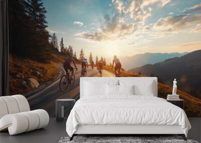 Cyclists team rides on mountain road at sunset sky. Wall mural