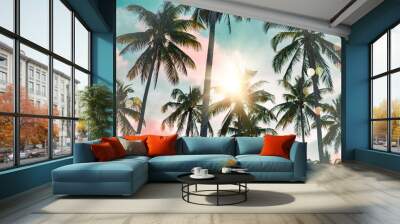 Tropical palm coconut trees on sunset sky flare and bokeh nature background. Wall mural