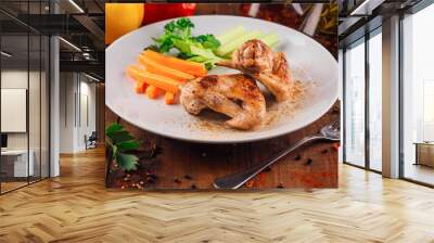 Delicious roasted chicken wings served with celery and carrot sticks on white plate Wall mural