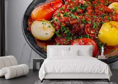 Spicy beef stew garnished with fresh herbs and vegetables on rustic plate Wall mural