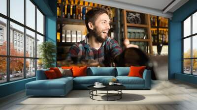 man barista preparing coffee for his customers while laughing Wall mural