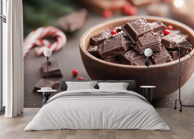 A bowl filled with dark chocolate and sweet candies. There are also candy canes scattered around the bowl, along with red and white sprinkles Wall mural