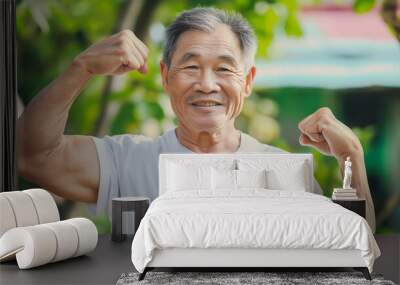 Smiling elderly patient Asian man flexing muscles and looking at camera feels healthy. Elderly healthcare concept. Showing biceps, muscles Wall mural