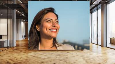 Close-up of a Latina woman smiling sideways. Copy space Wall mural