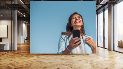 Portrait of a young Chinese girl happy with her cell phone. Copy space Wall mural